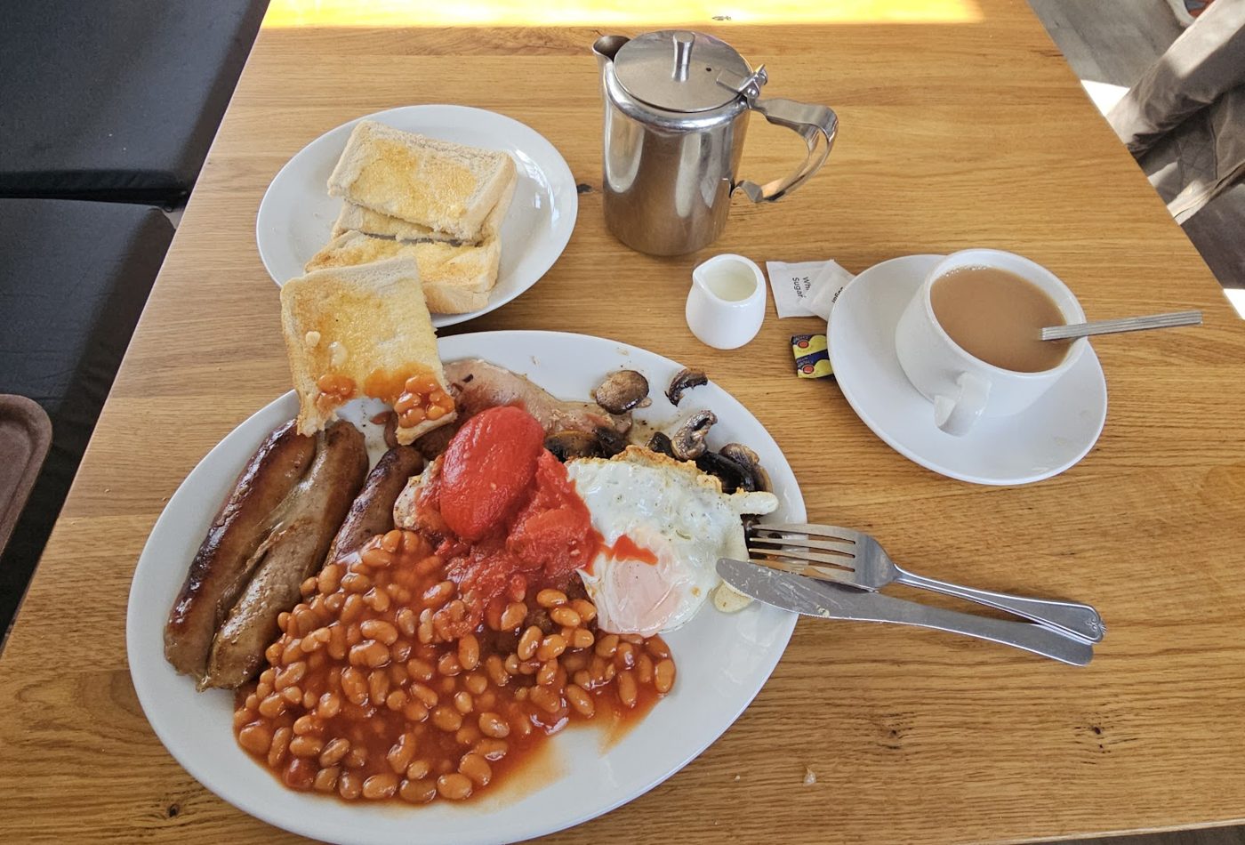 A cooked breakfast with toast and a hot drink